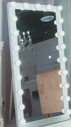 a large mirror with lights on top of it