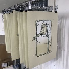 an image of a bird sitting on a branch in a window with curtains hanging from it