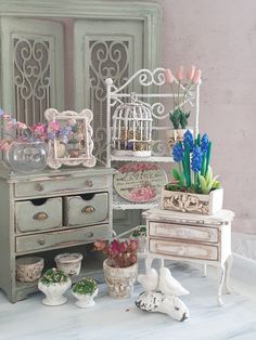 an assortment of miniature furniture and flowers on display