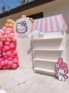 hello kitty balloons are on display in front of a store with pink and white decorations