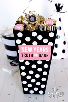 a black and white box filled with chocolates next to a polka dot table cloth