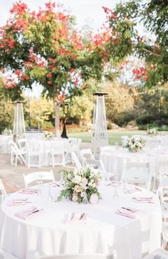 an outdoor wedding reception with white linens and pink flowers