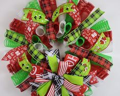 a christmas wreath made out of red, green and white ribbons with santa's faces on them