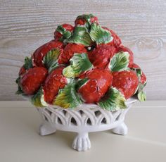 a white bowl filled with red strawberries on top of a table