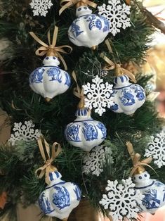 blue and white ornaments are hanging from a christmas tree