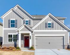 a gray house with white trim and red door