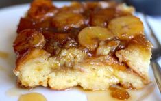 a piece of bread pudding with bananas on top and caramel sauce drizzled over it