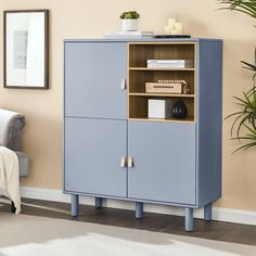 a blue cabinet sitting in the corner of a room next to a chair and potted plant