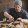 a man sitting at a table with plates of food