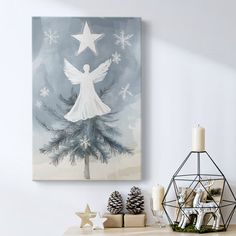 a christmas tree with an angel on it in front of a wall mounted canvas print