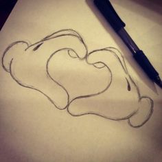 a drawing of a heart on paper with a pen