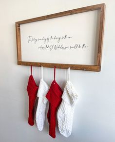 three stockings hanging from a wooden frame on a wall