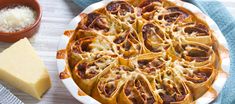 a pie with cheese and other food items on the table