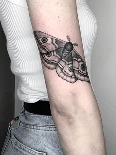 a moth tattoo on the right arm and left arm, it is black and white