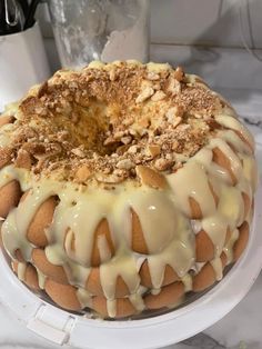 a cake sitting on top of a white plate covered in icing and toppings