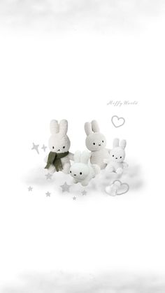 three white stuffed animals sitting next to each other on a white surface with stars around them