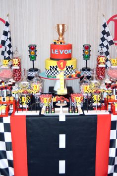 a table topped with lots of cakes and desserts next to a checkered wall