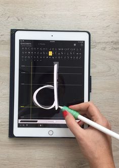 a person is using a pen to draw on an ipad with the letter d in it