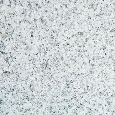 a close up view of a white granite counter top with black speckles on it