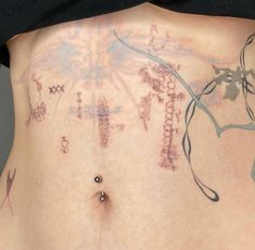 a woman's stomach with tattoos on it