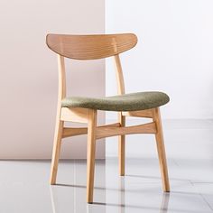 a wooden chair sitting on top of a white tile floor next to a pink wall