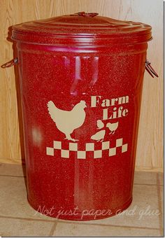 a red trash can with the words farm life painted on it and a chicken sitting inside