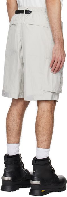 Polyester taffeta shorts. · Integrated FIDLOCK® cinch belt at elasticized waistband · Belt loops · Four-pocket styling · Mock-fly · D-ring hardware and logo plaques at front · Magnetic zip flap at outseams · Velcro tab at back cuffs · Full poplin lining Supplier color: Light gray Nylon Bottoms With Belt Loops For Summer, Outdoor Nylon Shorts With Belt Loops, Nylon Shorts With Belt Loops For Summer, Summer Nylon Shorts With Belt Loops, Casual Shorts For Men, Cinch Belt, Mens Cuff, Track Shorts, Distressed Shorts