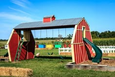 a red barn with a green slide in it