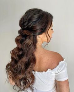 a woman with long hair wearing a white top