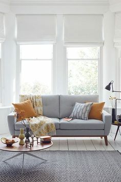 a living room filled with furniture and lots of windows