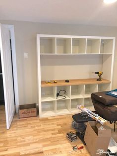 a living room with hard wood floors and white bookcases