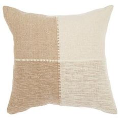 a beige and white pillow with two different squares on the front, one is made out of