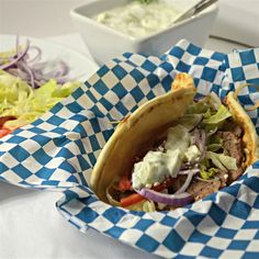 a close up of a taco in a basket on a table with other food