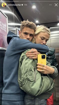 a man and woman hugging each other in an elevator