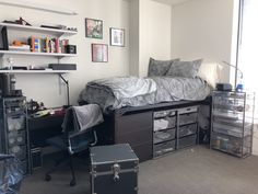 a bedroom with a bed, desk and drawers