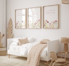 a bedroom with two framed pictures on the wall and a white bed in front of it