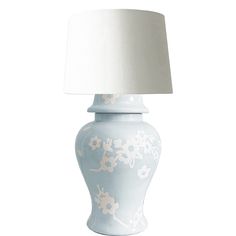 a white and blue vase with a lamp on top