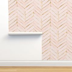 a white shelf sitting next to a wall with a pink and gold pattern on it