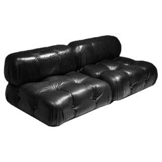 a black leather couch sitting on top of a white floor