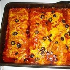 an enchilada casserole with olives in a baking pan on the stove