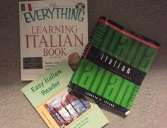 three books sitting on top of a carpeted floor next to an open laptop computer