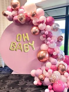 the balloon arch is decorated with pink, gold and white balloons that spell out oh baby