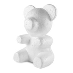 a white teddy bear sitting on top of a white floor next to a black and white wall