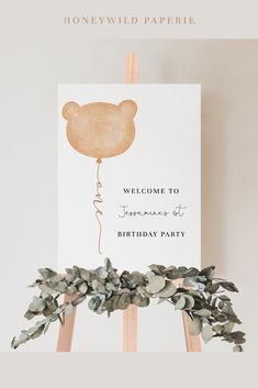 a welcome sign with a bear balloon attached to it