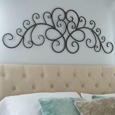 the headboard of a bed is made up with decorative iron art work on it