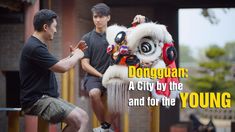 two men sitting on top of a bench next to a white dragon statue with the words, dongguan a city by the and for the young