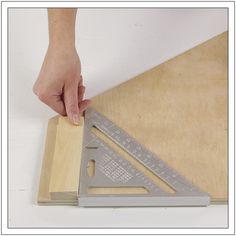 a person is measuring the width of a piece of wood with a large metal ruler