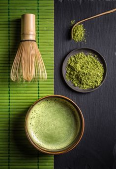 matcha powder and whisk in bowls on bamboo mat