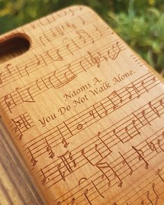 a wooden cutting board with musical notes engraved on the front and sides, along with words written in cursive writing