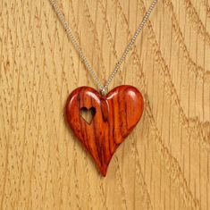 a wooden heart shaped pendant on a chain